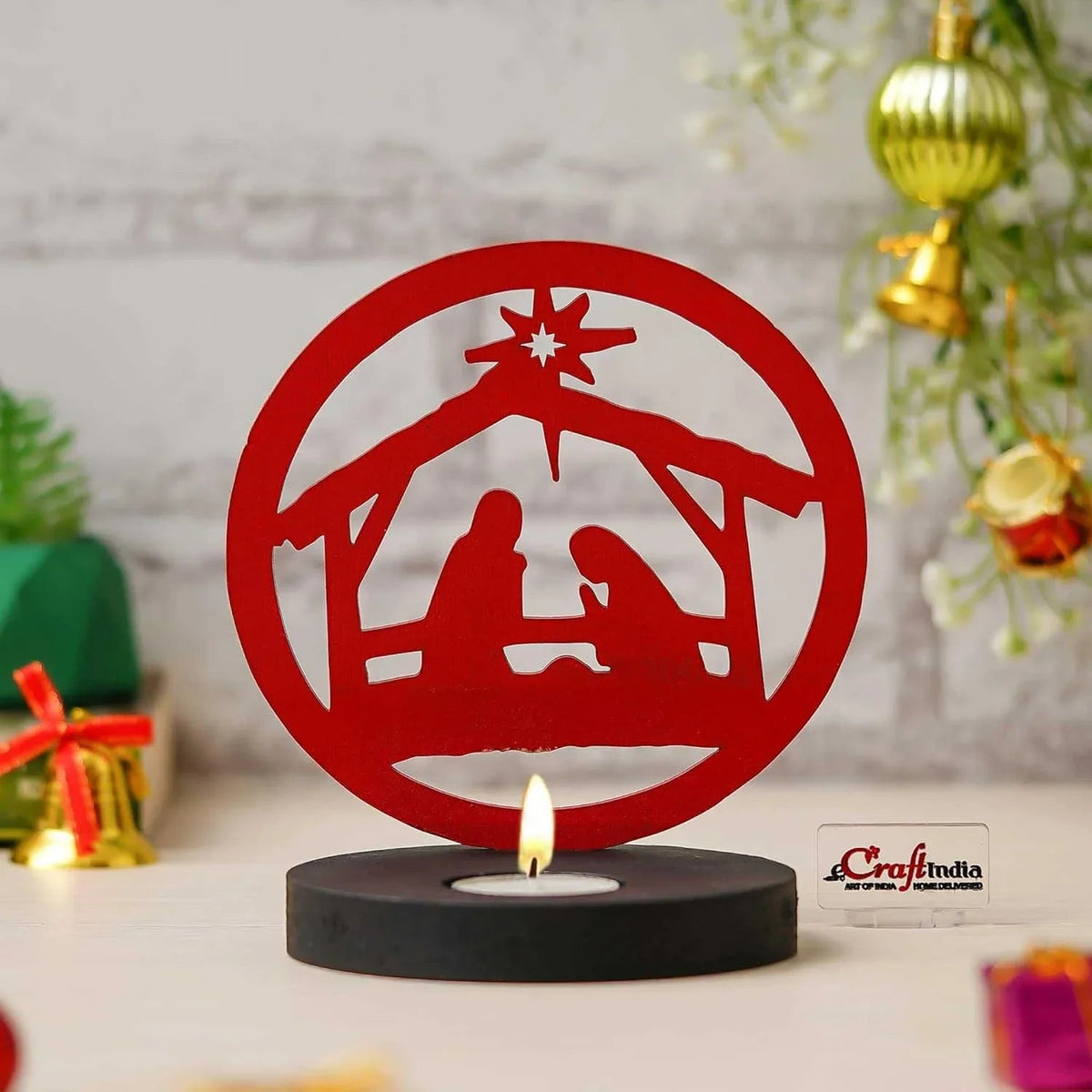 Red nativity scene candle holder with a lit candle