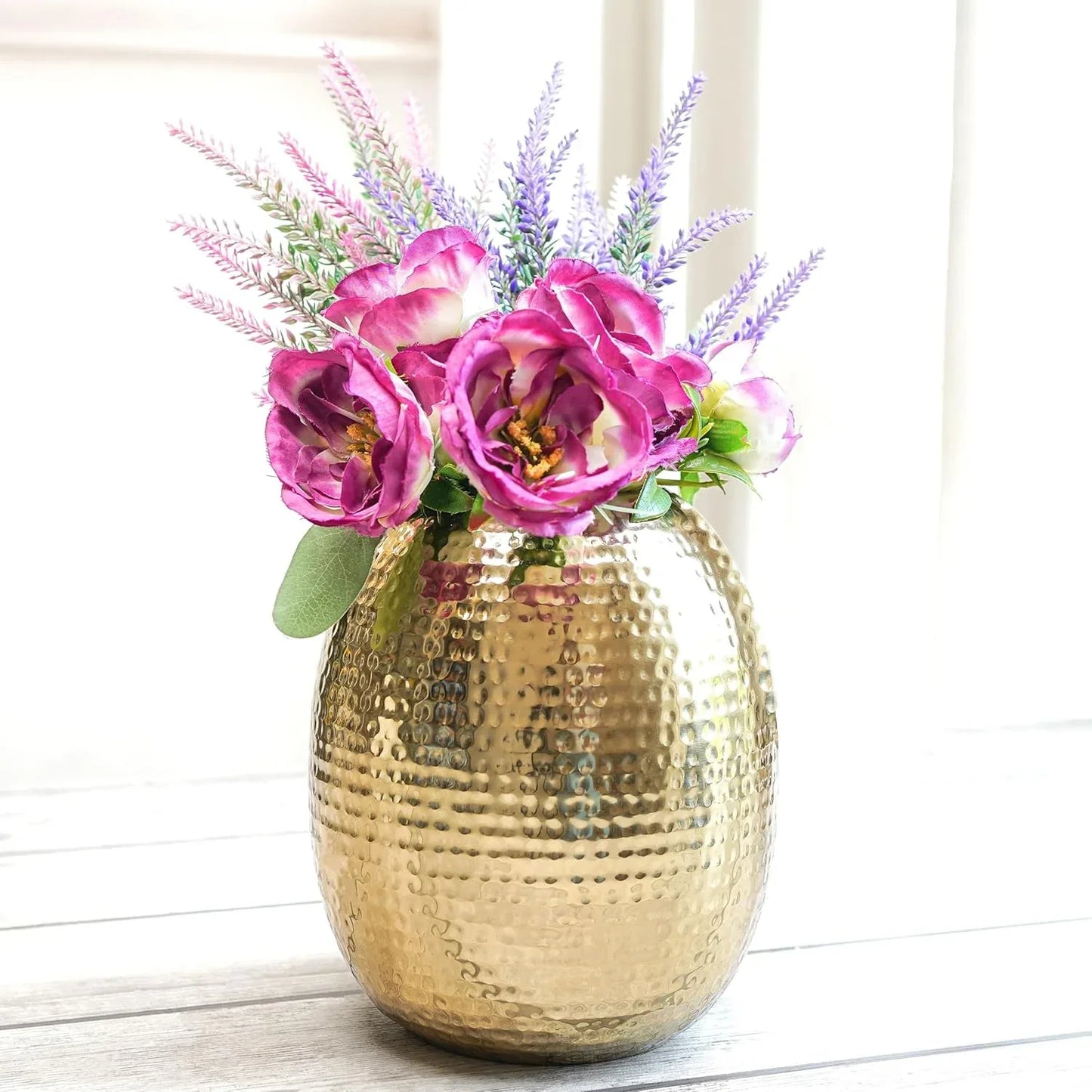 Gold vase with pink flowers on a white background