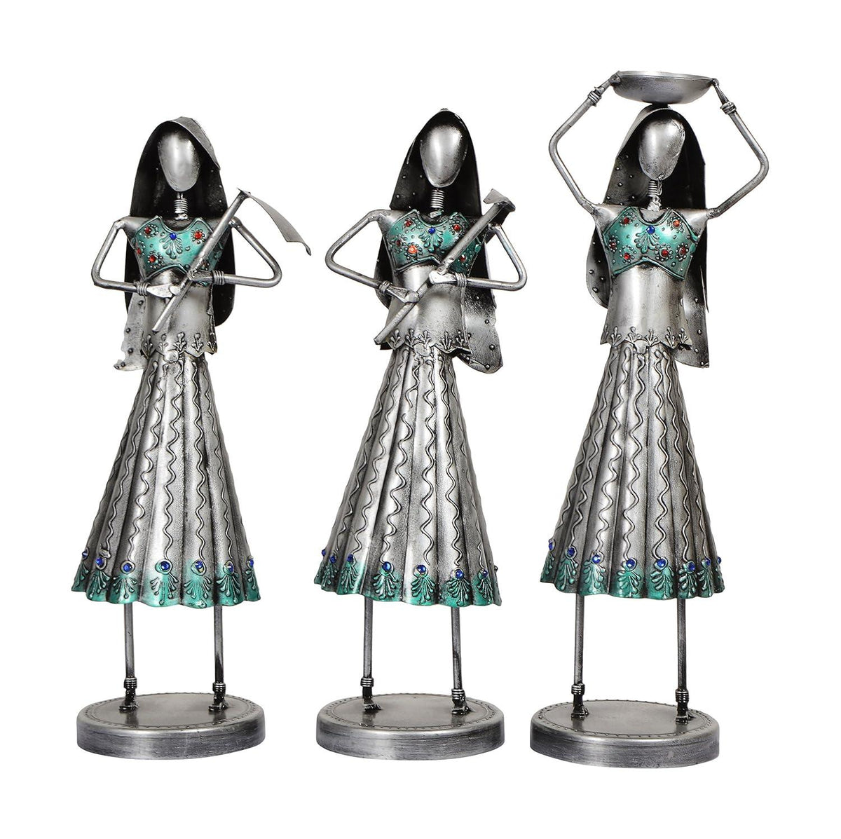 Three metallic figurines with decorative dresses on a white background