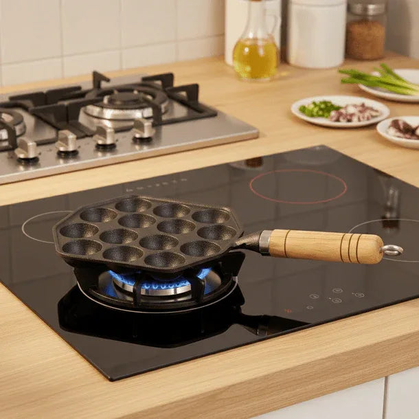 Black pan with wooden handle on a gas stove in a kitchen setting