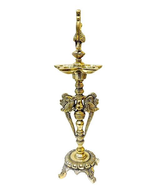 Traditional brass oil lamp (diya) with ornate carved design and sturdy base.