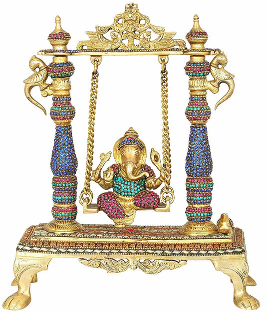 Handcrafted 13.2-inch brass Ganesha on swing jhula idol — stone-studded pillars in blue, pink and green, gold chain swing, decorative arch crown and lion-paw footed base — ArtyCraftz