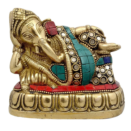 Handcrafted 4-inch solid brass reclining Ganesha idol with turquoise and coral stone inlay on garment and cushion, resting on lotus base — unique lazy Ganpati statue — ArtyCraftz