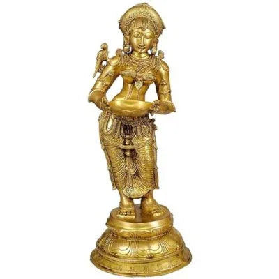 A brass standing deep lady with a parrot diya statue, holding a golden bowl and a bird perched on her shoulder.