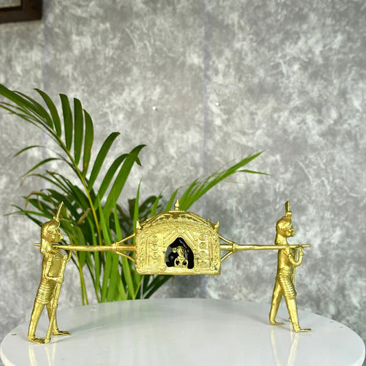 Gold-colored sculpture of two figures pulling a chariot with a small figure inside on a white platform