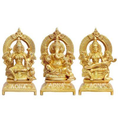 Set of 3 handcrafted 7-inch solid brass Lakshmi, Ganesha and Saraswati idols each with ornate prabhavali arch and engraved footed base — antique gold finish temple trio — ArtyCraftz