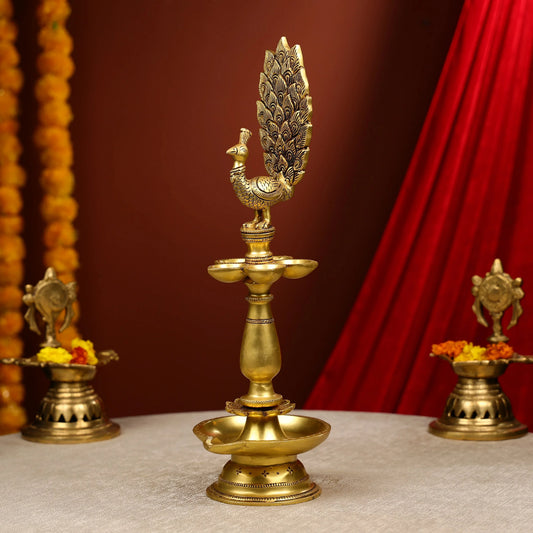 Decorative brass lamp with peacock design on a red and brown background