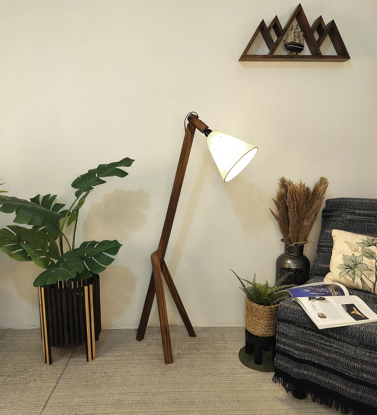 Wooden floor lamp in a living room setting with plants and a sofa.