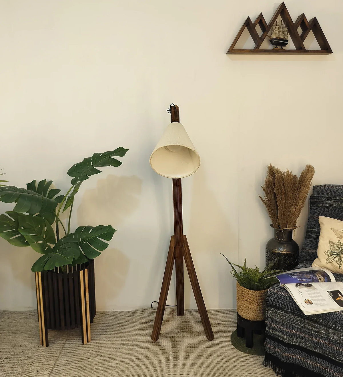 Wooden floor lamp in a room with plants and a chair.