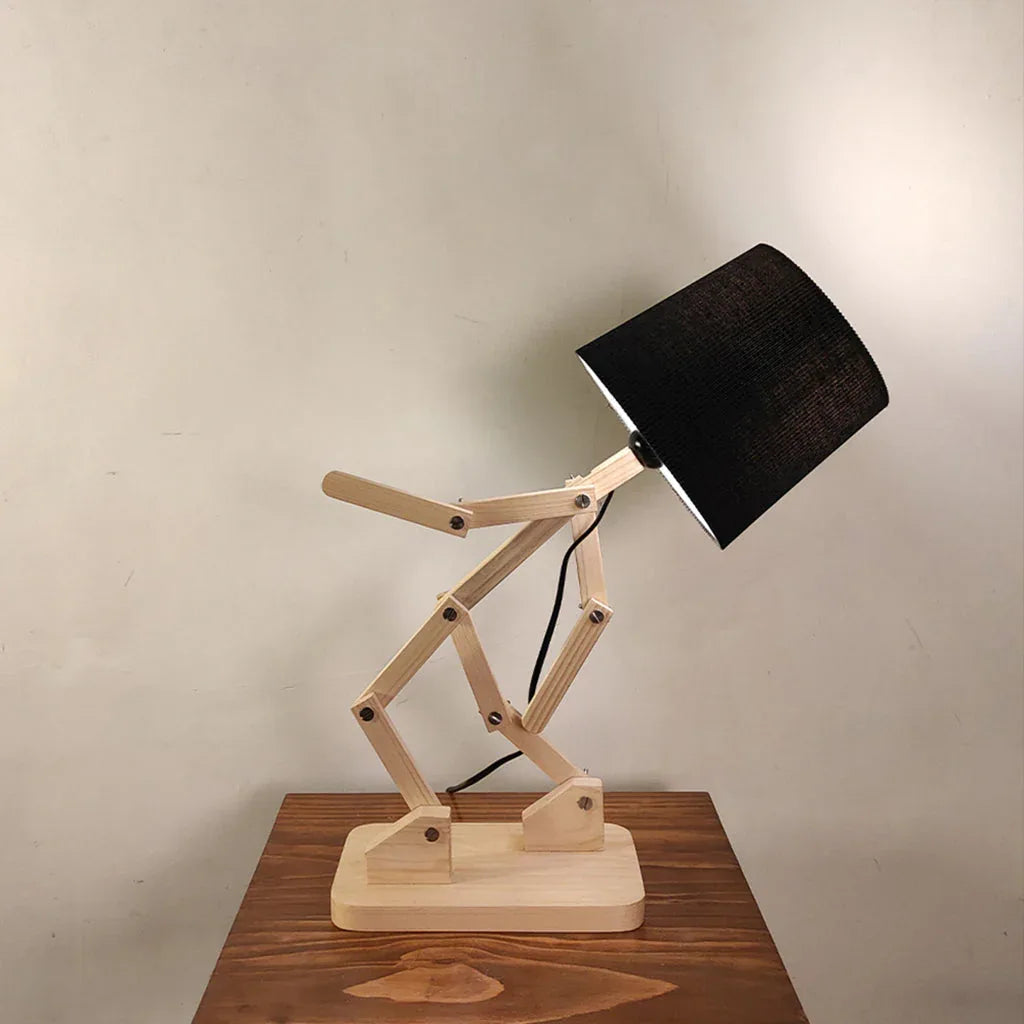 Wooden desk lamp with black shade on a wooden surface against a plain background
