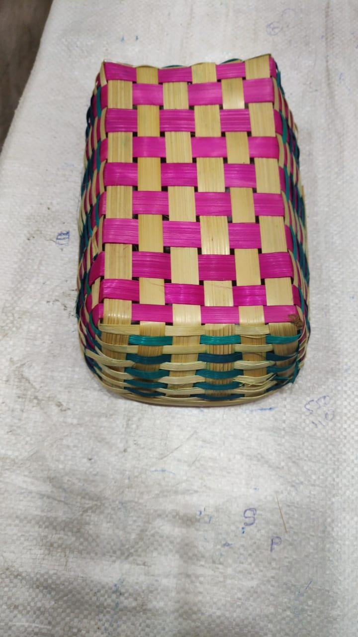 Woven box with pink and green pattern on a gray surface