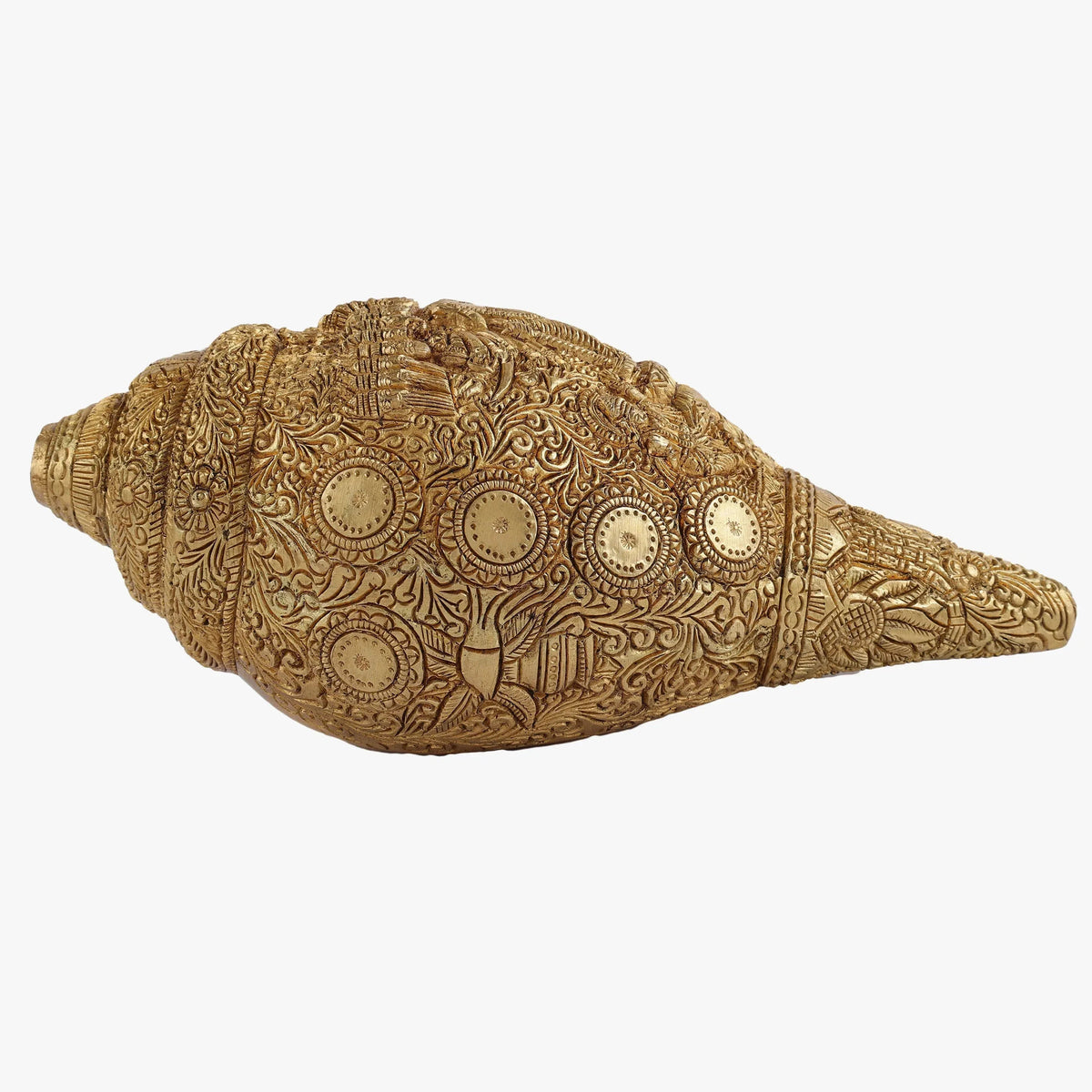 Decorative brass conch shell with intricate patterns on a white background