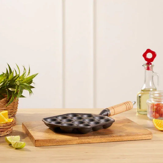 Black frying pan on a wooden cutting board