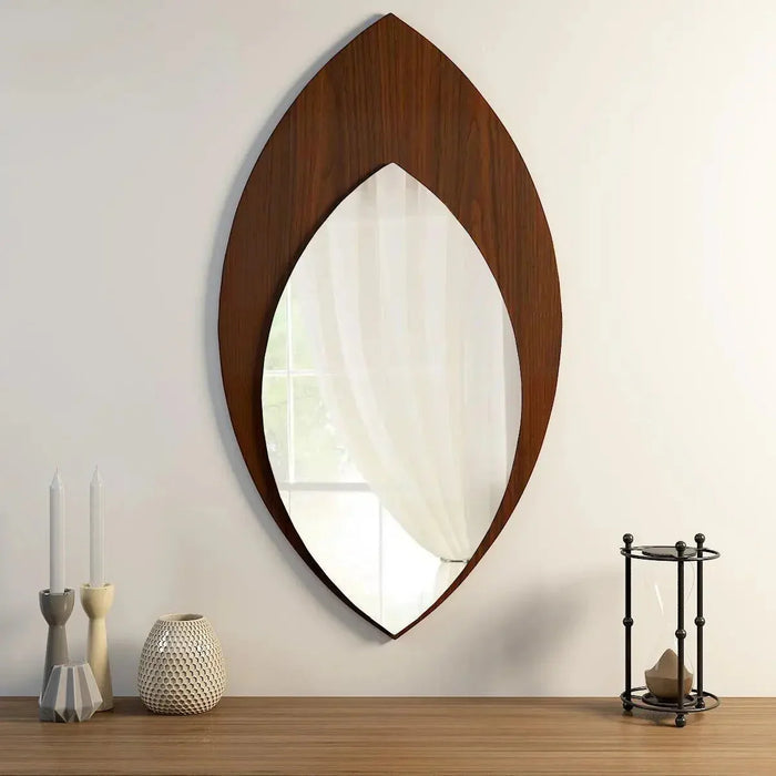Wooden-framed mirror on a wall with decorative items below.