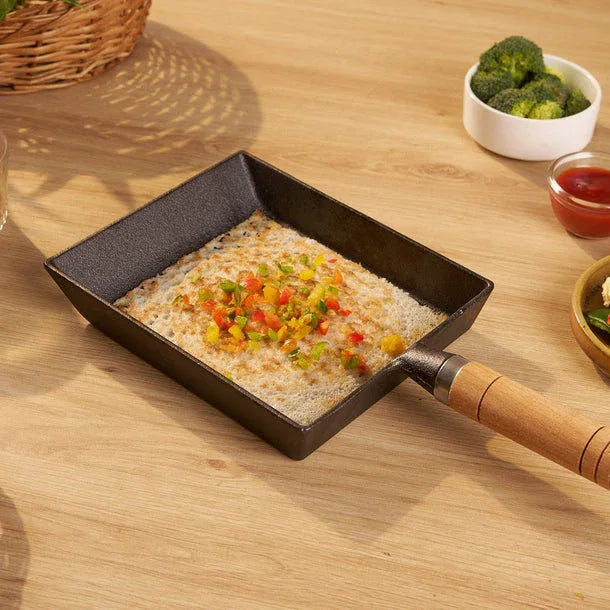 Small frying pan with food on a wooden table