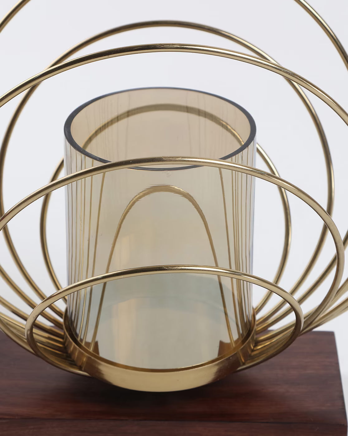 Gold wire basket with a glass container on a wooden surface