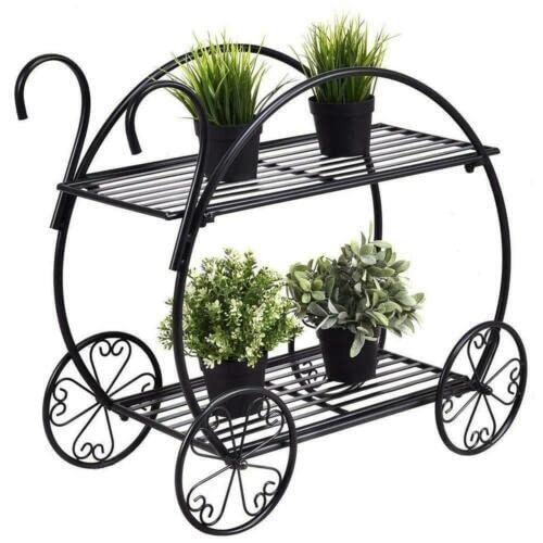 Black metal plant stand with two shelves holding potted plants