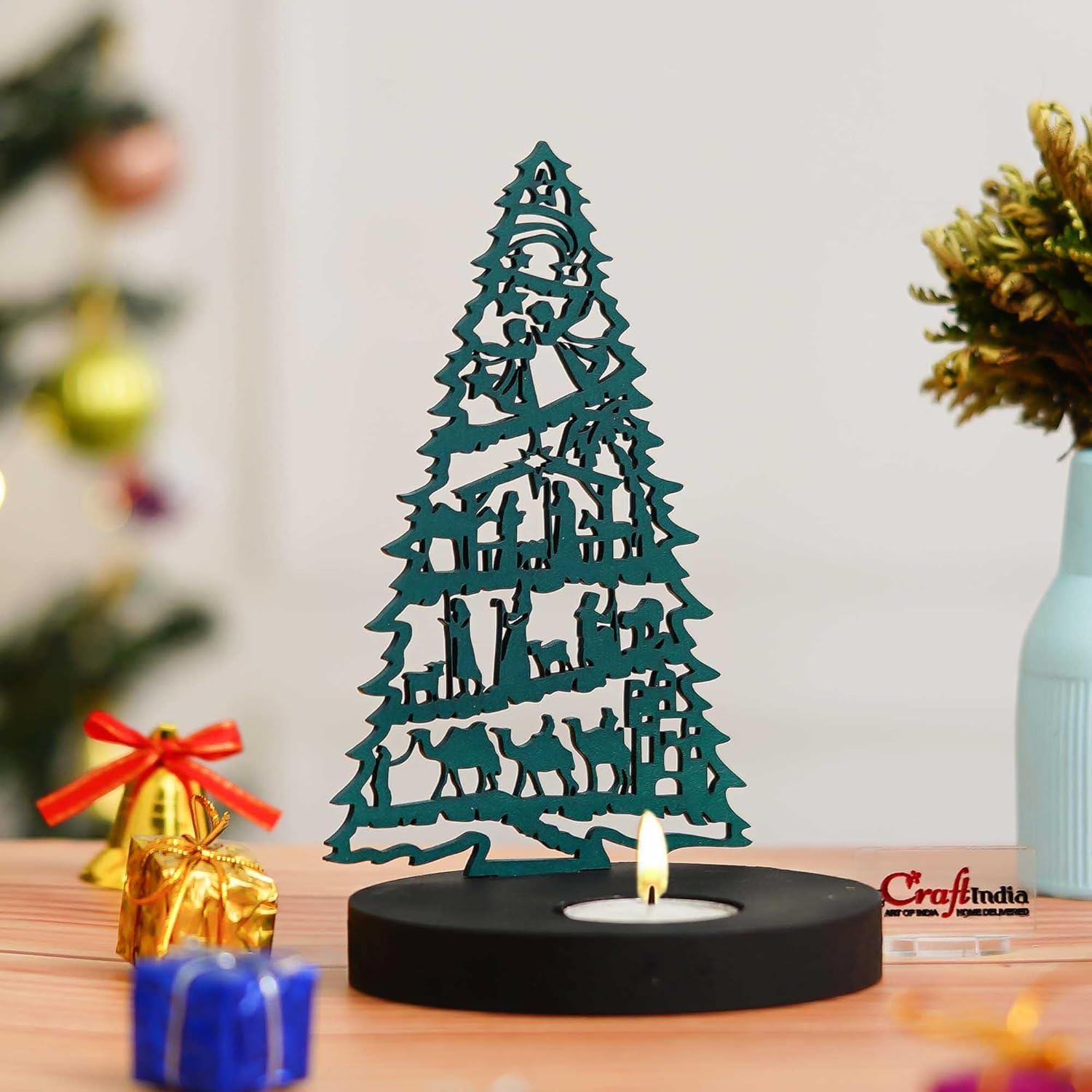 Decorative teal metal Christmas tree on a wooden table