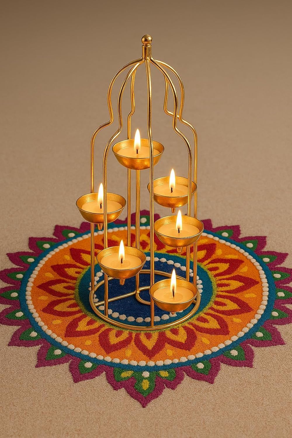 Decorative gold candle holder with lit candles on a colorful rangoli design.