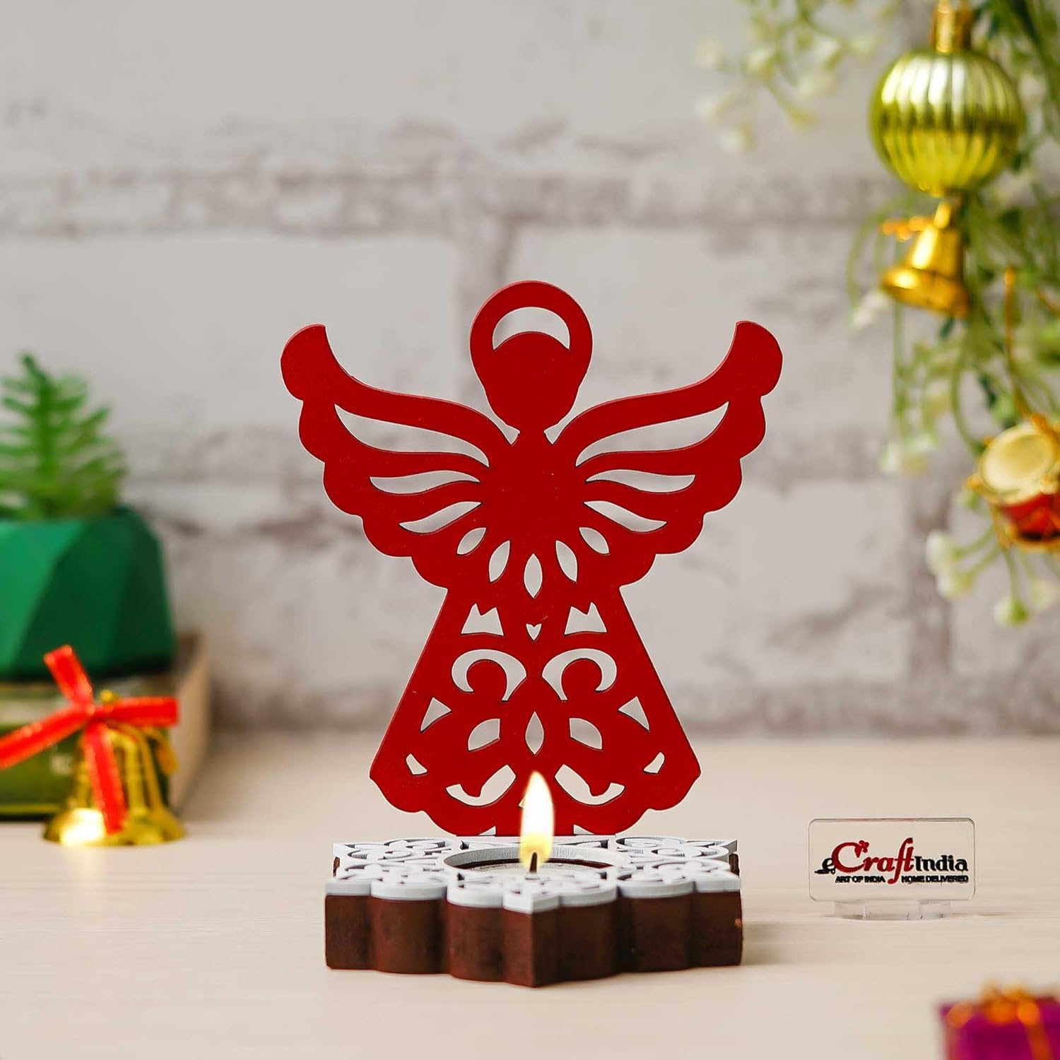 Red angel-shaped candle holder with a lit candle