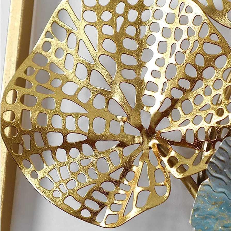 Gold leaf-shaped decorative item with intricate cut-out patterns on a white background
