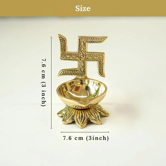 Gold-colored oil lamp with swastika design and measurements
