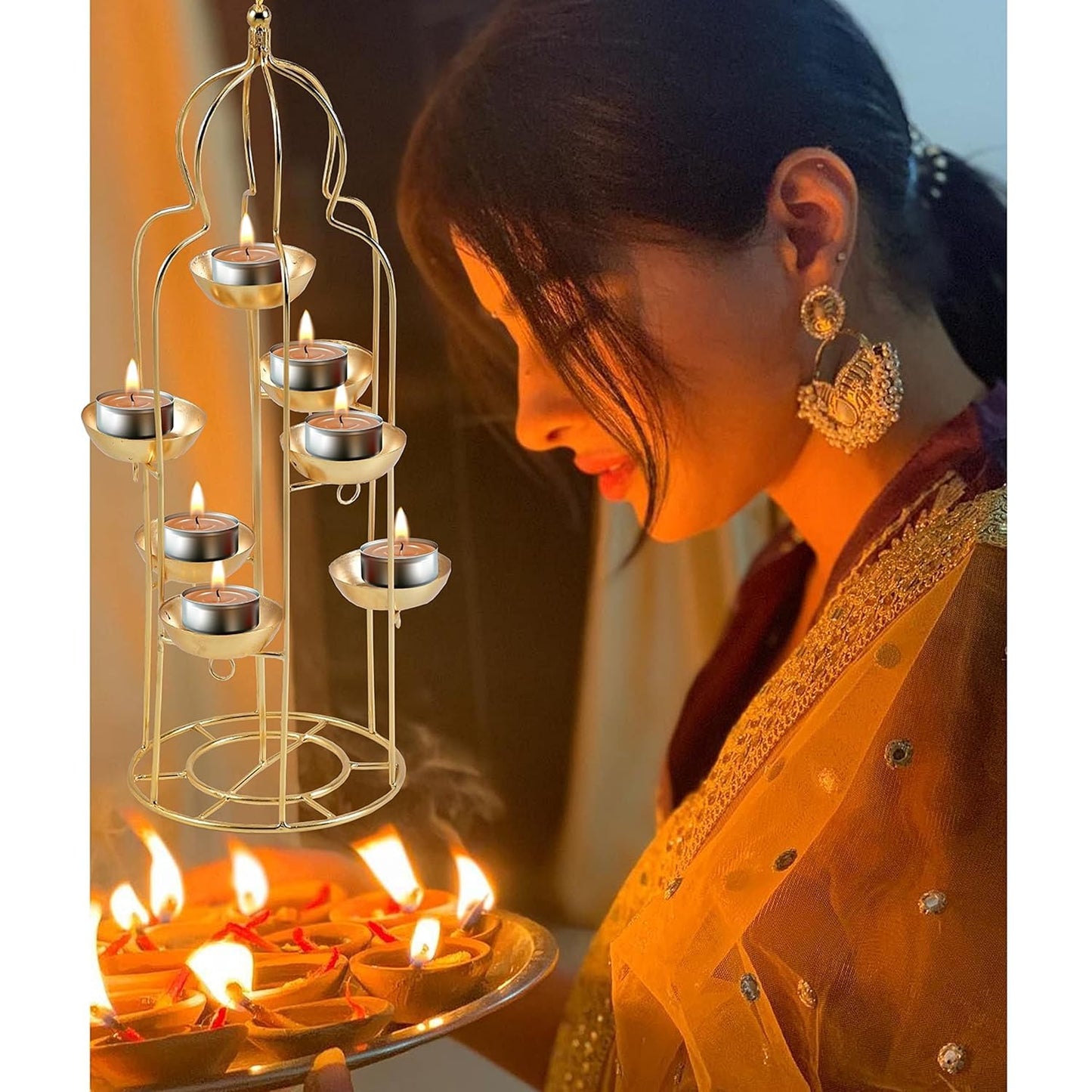 Woman in traditional attire with lit candles and a decorative metal holder.