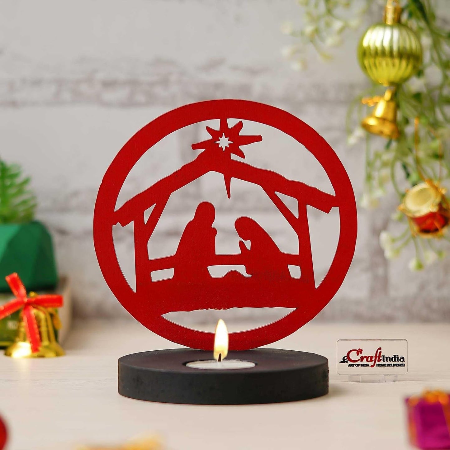 Red nativity scene candle holder with a lit candle