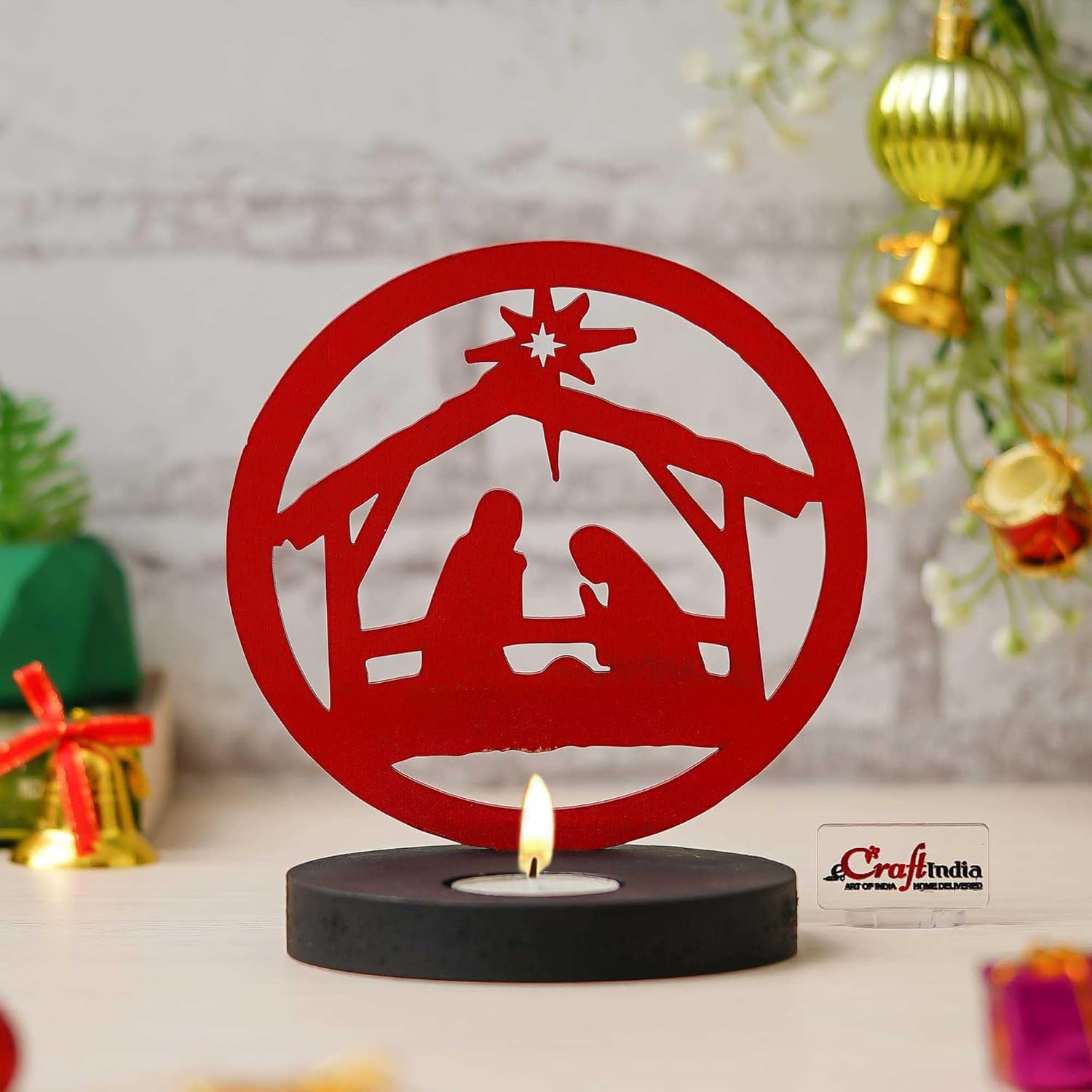 Red nativity scene candle holder with a lit candle