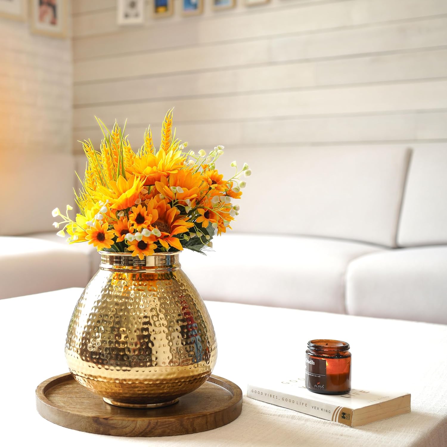 Gold vase with yellow flowers on a wooden tray in a living room setting