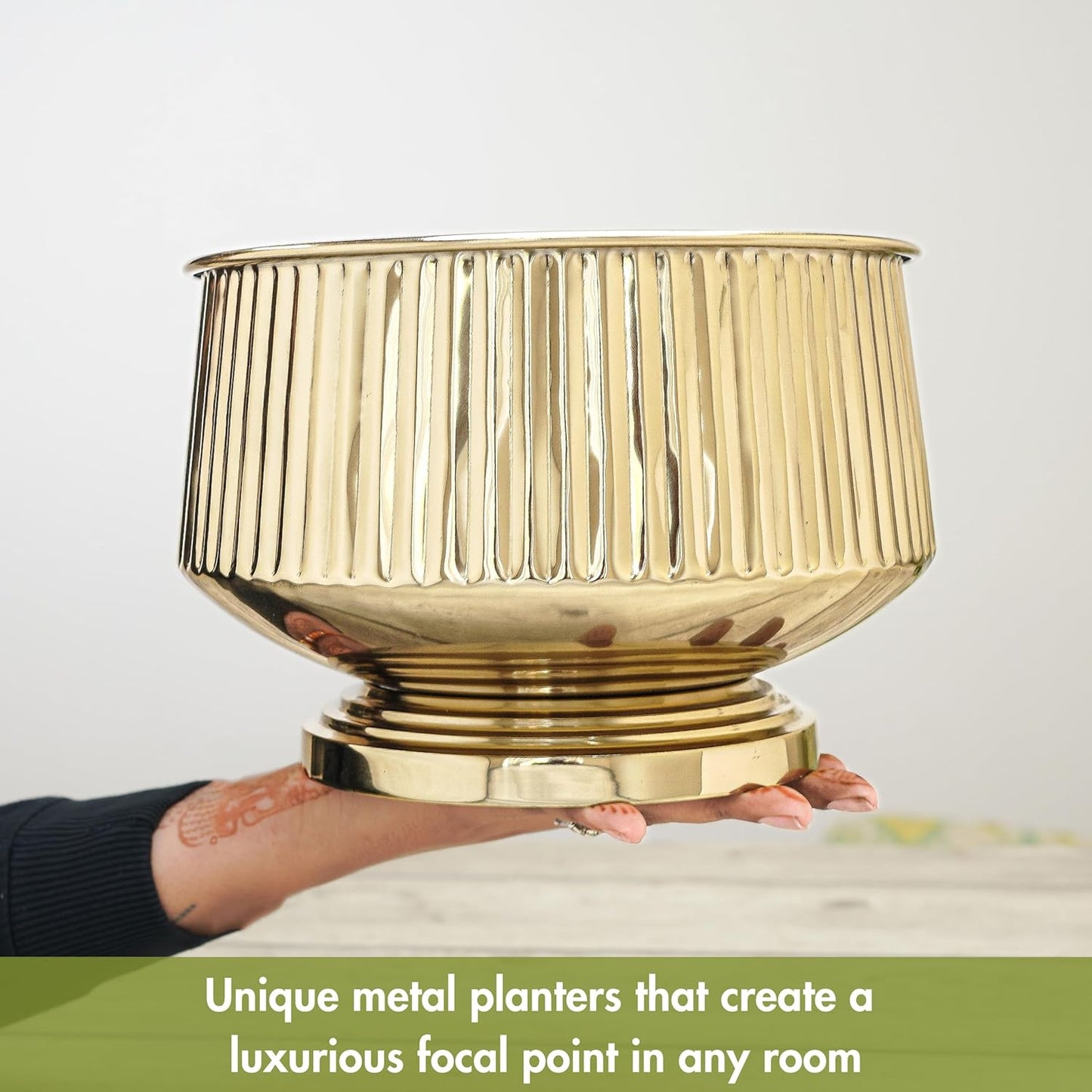 Gold metal planter held by a person with text describing its luxurious appeal.