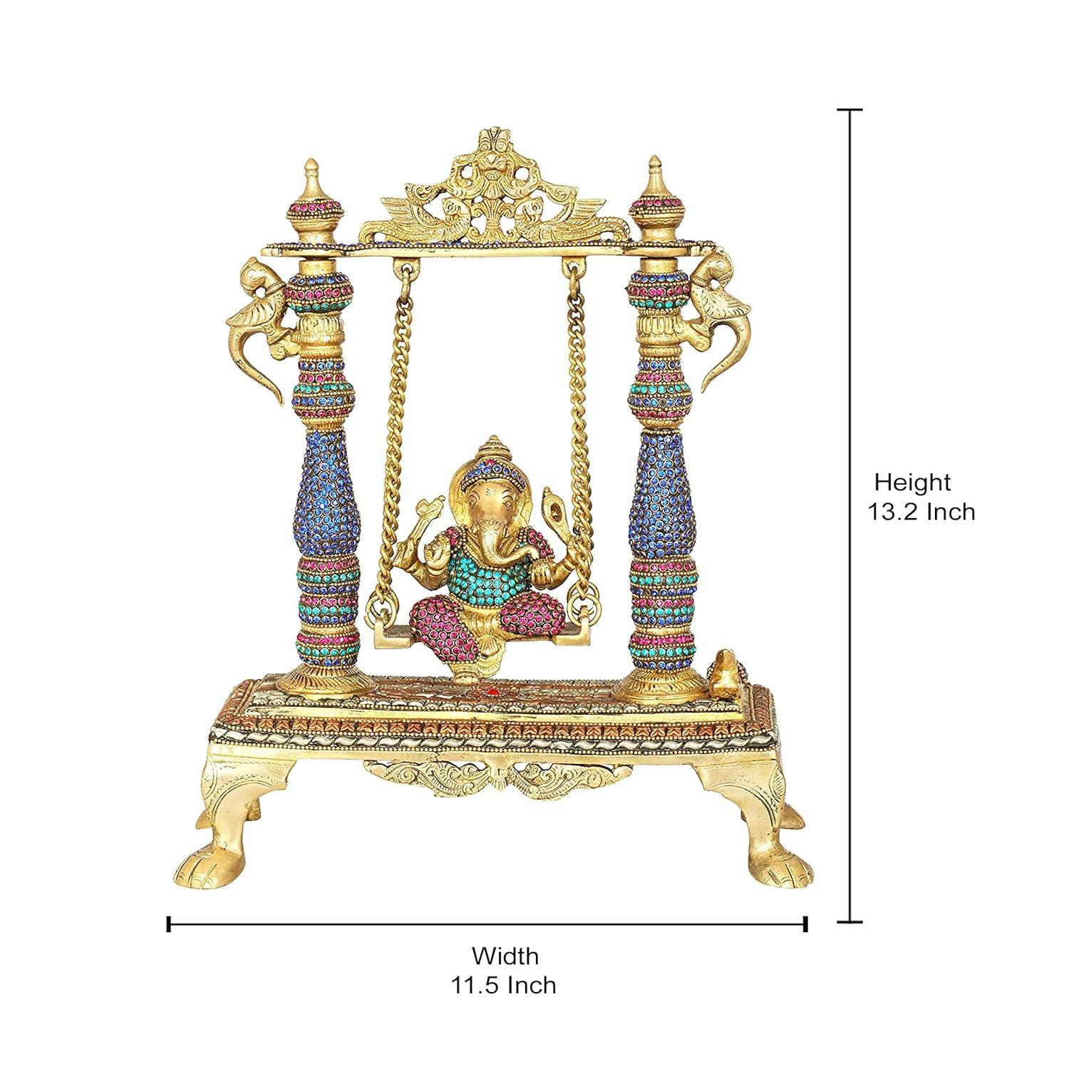 Handcrafted 13.2-inch brass Ganesha on swing jhula idol — stone-studded pillars in blue, pink and green, gold chain swing, decorative arch crown and lion-paw footed base — ArtyCraftz