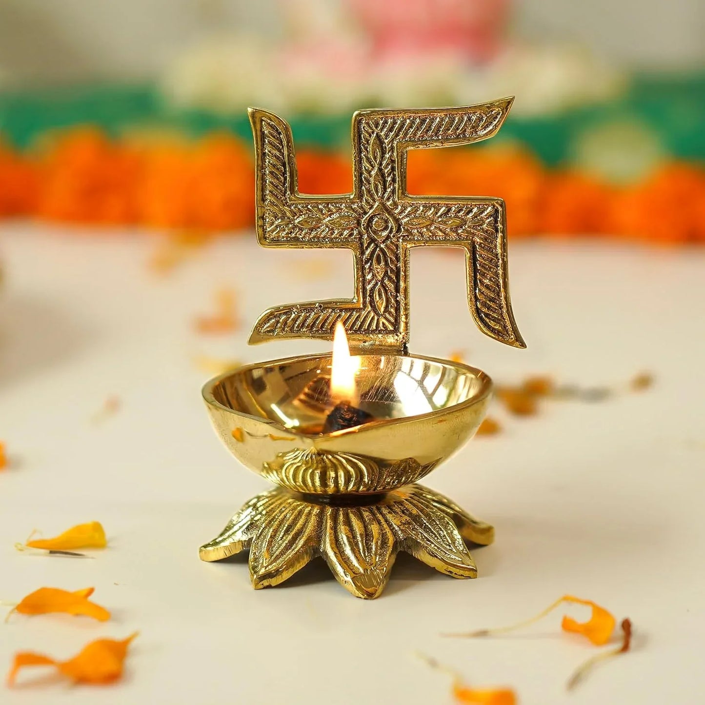 Decorative brass lamp with a lit candle and swastika symbol