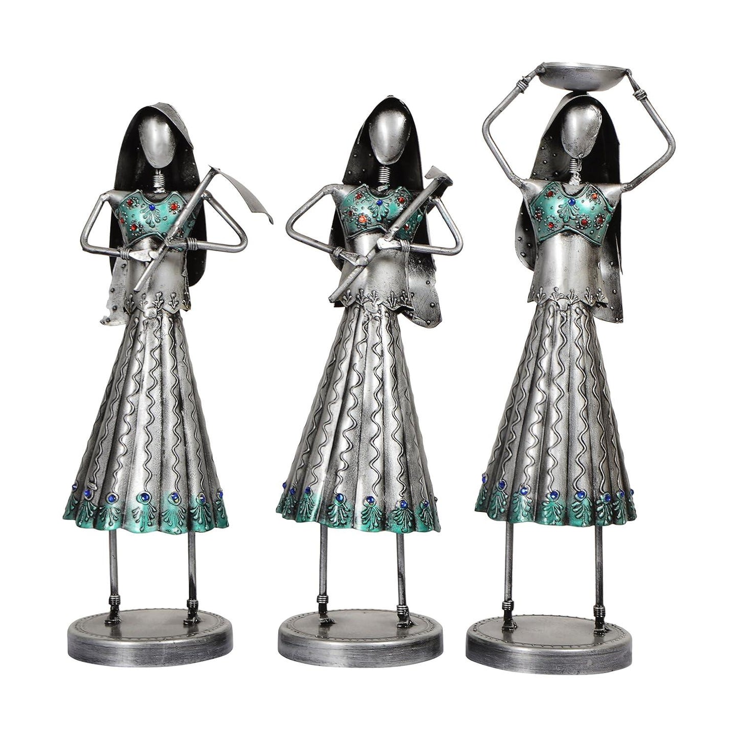 Three metallic figurines with decorative dresses on a white background