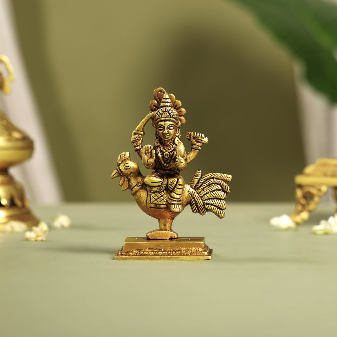 Brass statue of goddess parvathi on a green surface with a blurred background