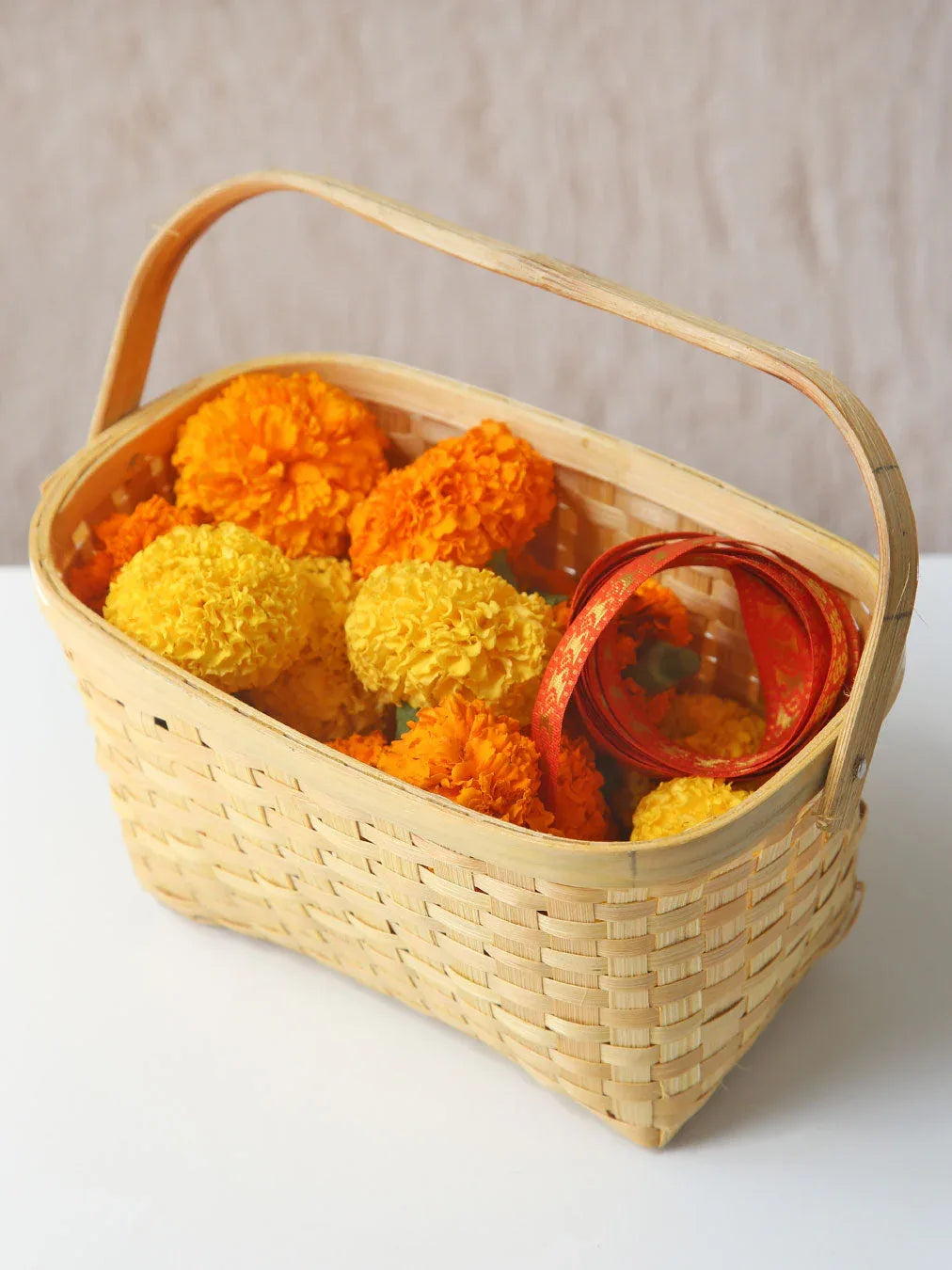 Basket with marigold flowers and ribbons