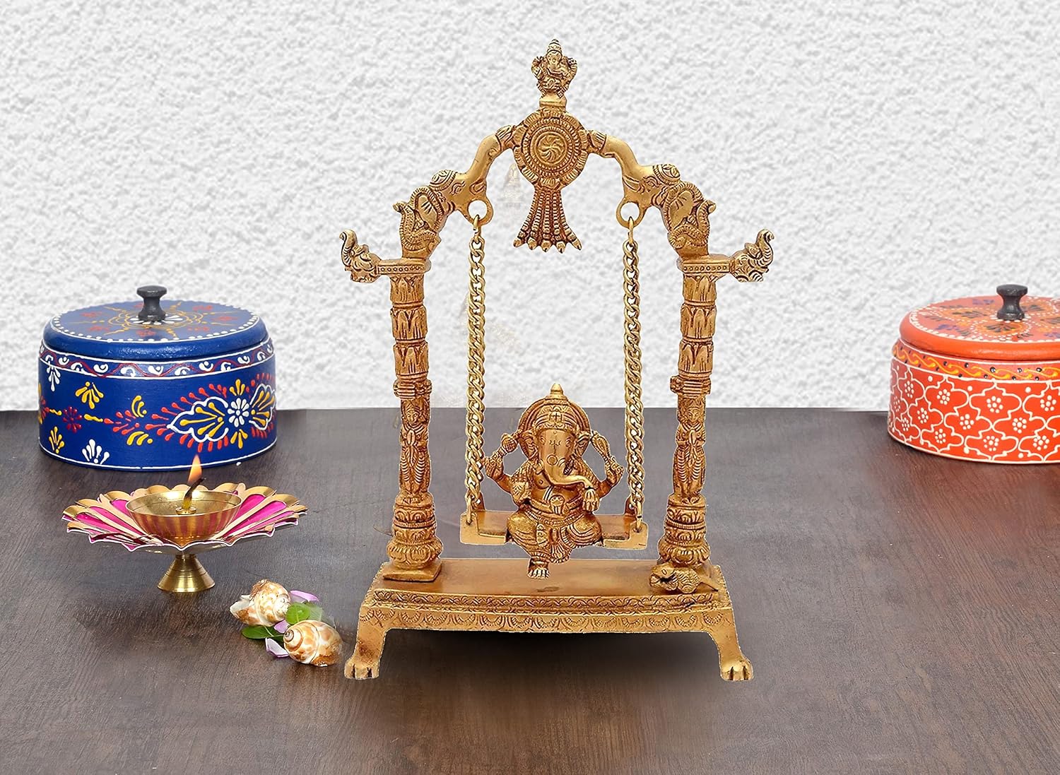 Handcrafted 12.5-inch solid brass Ganesha on swing Jhula idol — South Indian temple style with elephant pillar capitals, Ganesha arch finial, brass chain suspension, Mooshika at base — ArtyCraftz