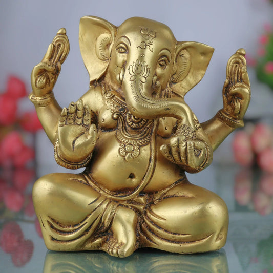 Handcrafted 16 cm solid brass Ganesha idol seated in Sukhasana with Om and lotus engraved on forehead, four arms in blessing pose, antique gold finish — ArtyCraftz