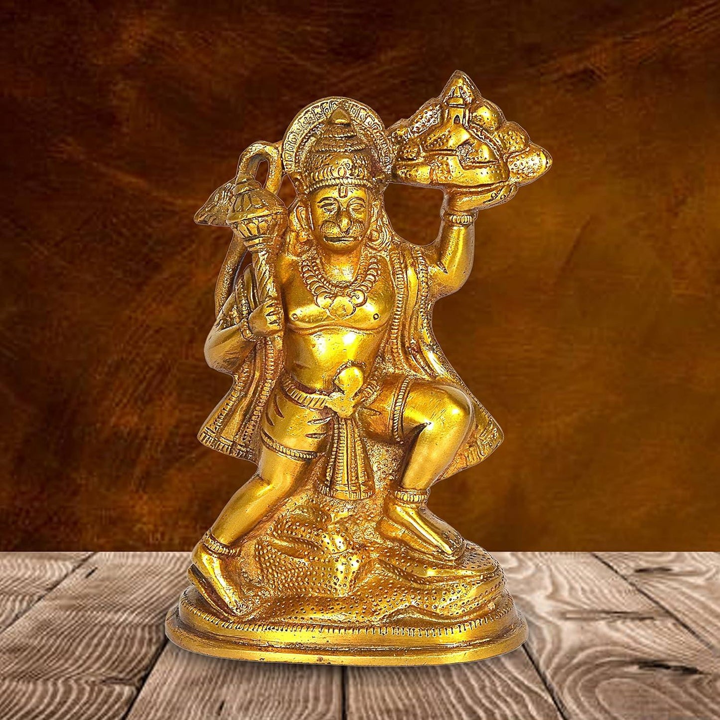 Handcrafted 6.5-inch solid brass Hanuman idol — flying pose carrying Sanjeevani mountain in right hand and gada in left, antique gold finish on oval base — ArtyCraftz