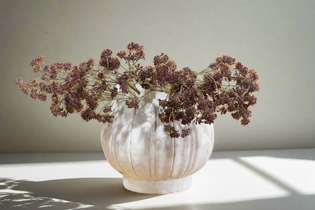 White textured vase with dried flowers on a light background
