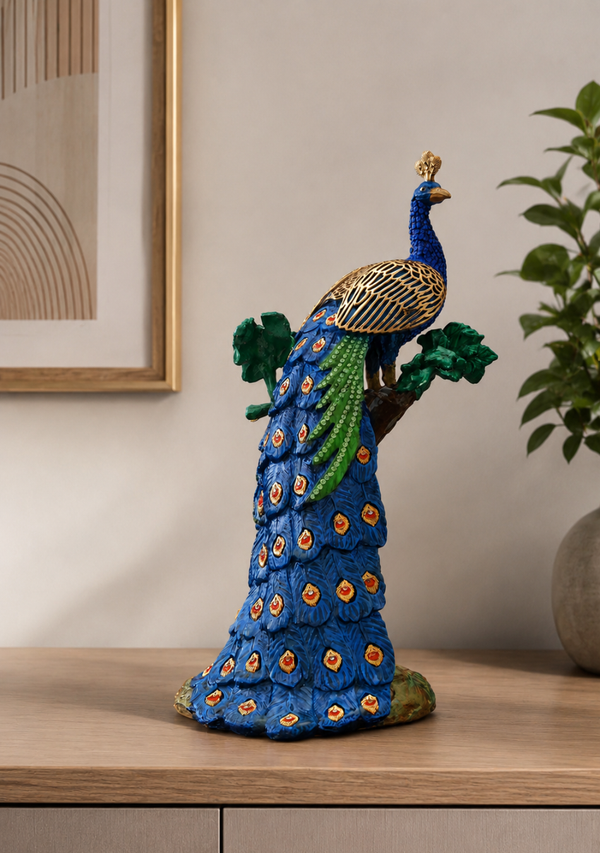 Decorative peacock sculpture on a wooden surface with a neutral background