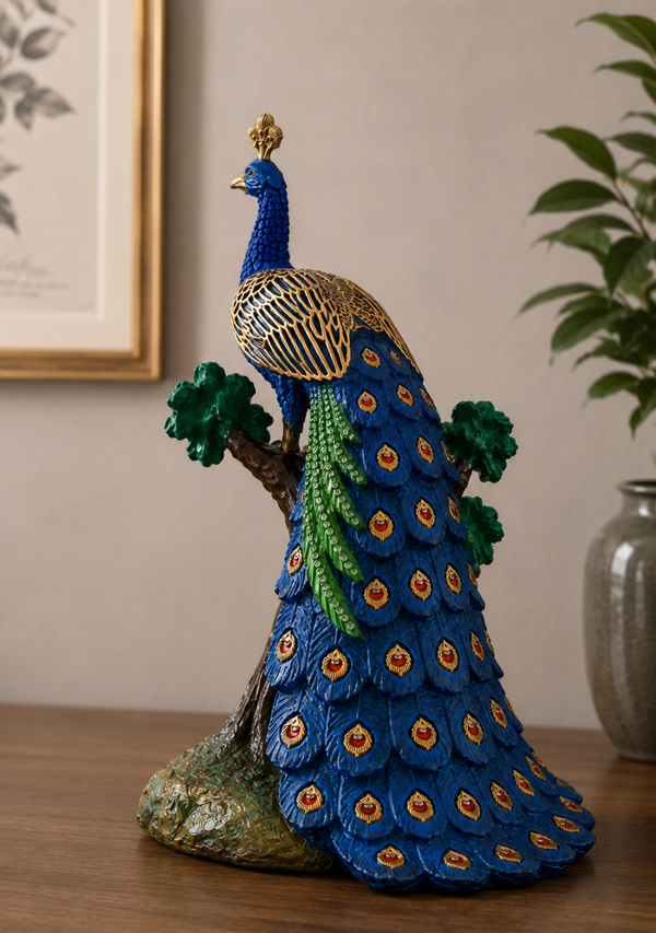 Decorative peacock figurine on a branch with a vase and plant in the background