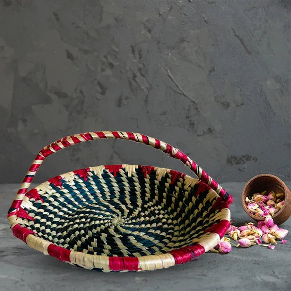 Woven basket with red and black pattern on a gray surface
