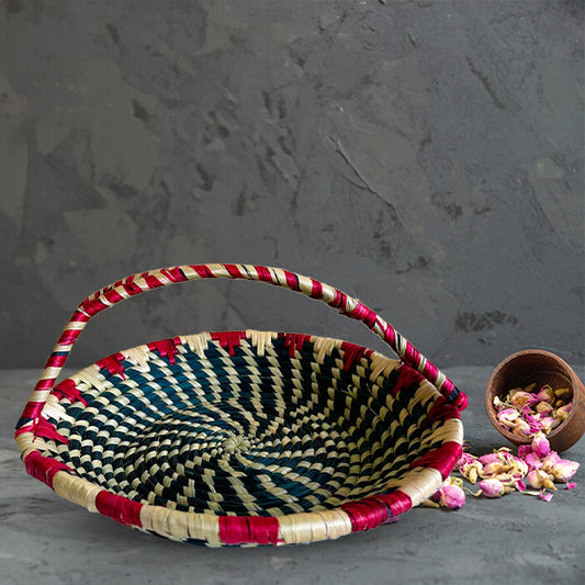 Woven basket with red and black pattern on a gray surface