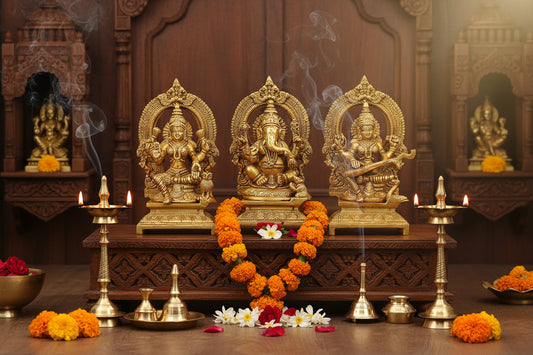 Set of 3 handcrafted 7-inch solid brass Lakshmi, Ganesha and Saraswati idols each with ornate prabhavali arch and engraved footed base — antique gold finish temple trio — ArtyCraftz