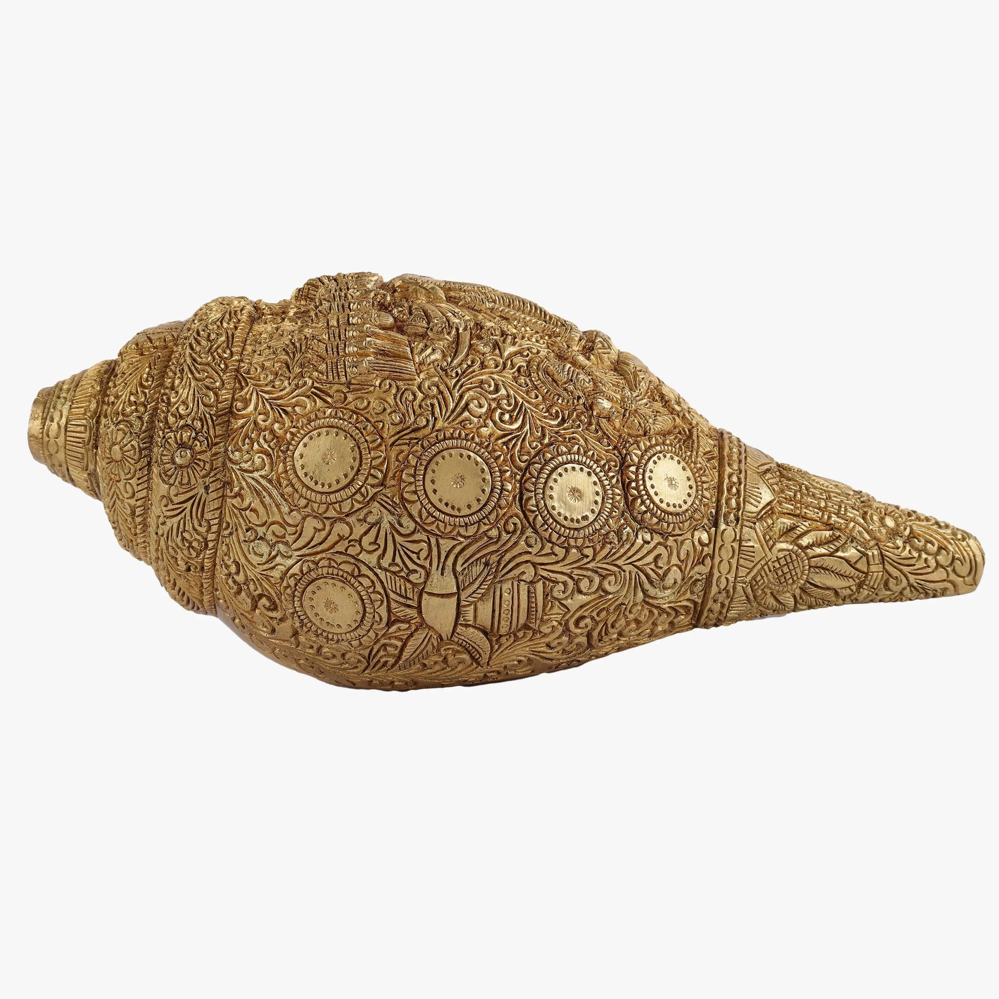 Decorative brass conch shell with intricate patterns on a white background