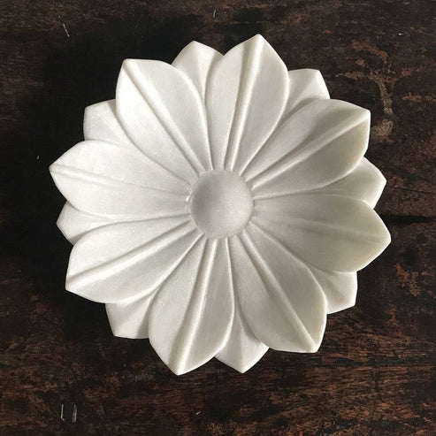 White decorative flower-shaped object on a dark wooden surface