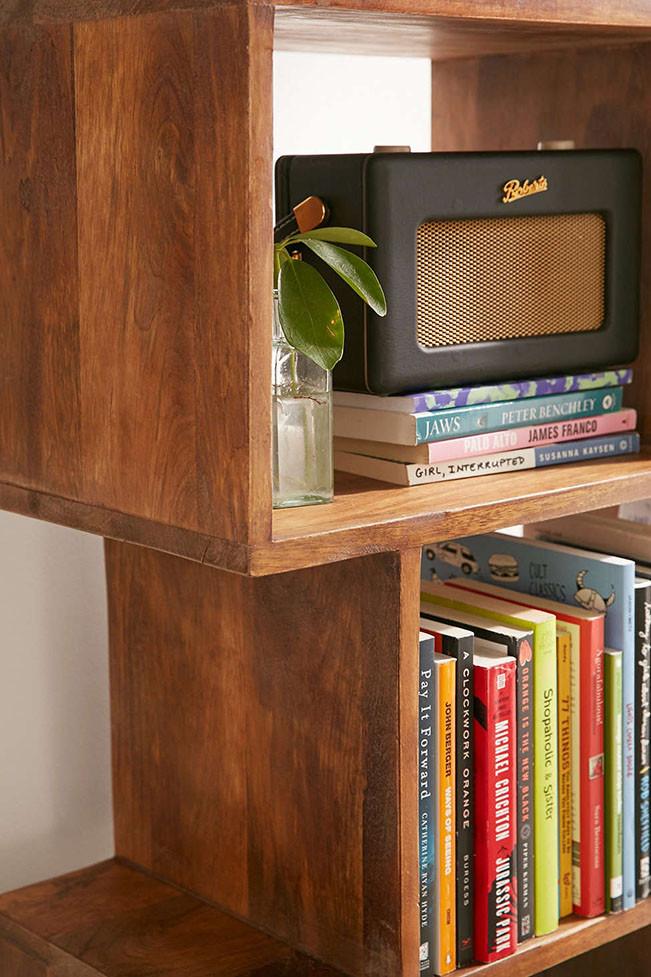 Wooden shelf with books and a radio on a white background
