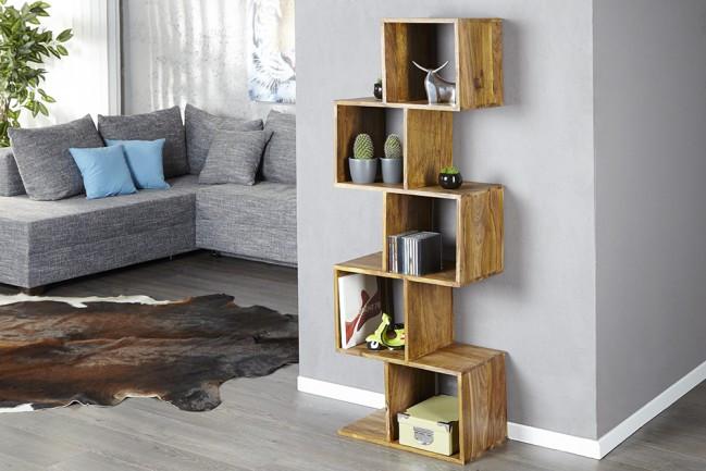 Wooden bookshelf in a living room with a gray sofa and decorative items.