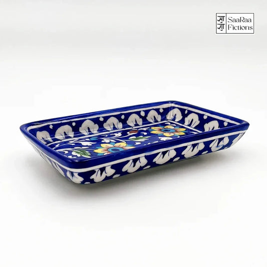 Ceramic tray with blue border and white floral patterns on a white background